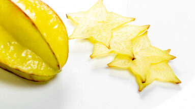 Sliced star fruit arranged on a white surface for juicing.